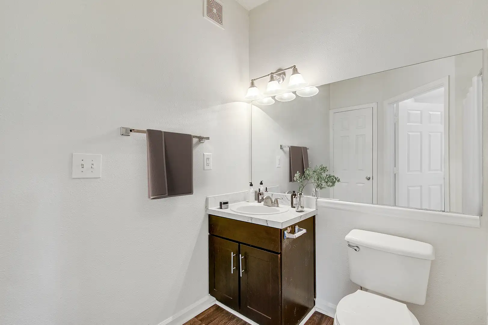 Bathroom with woodlike flooring and a sink with counterspace