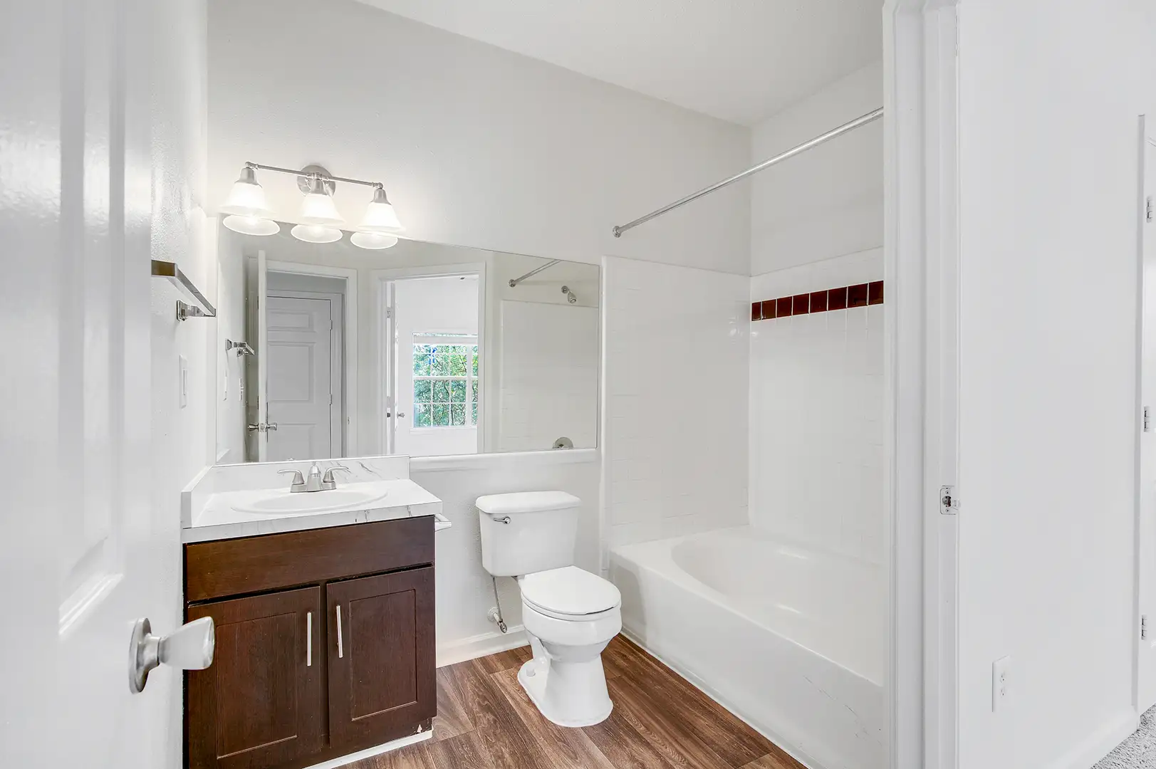Bathroom with woodlike flooring, a sink with counterspace, and a tub with a shower.