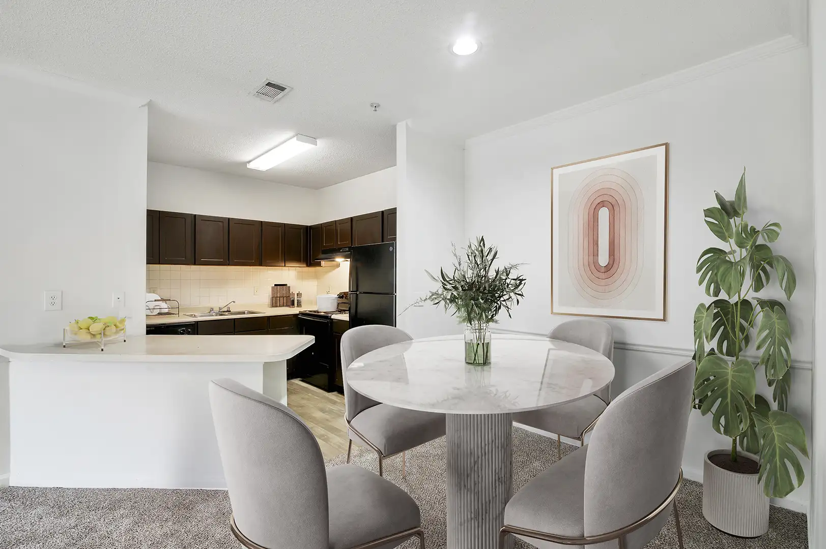 Model dining area next to a kitchen with wood-like floor, espresso cabinetry, and stainless steel appliances.