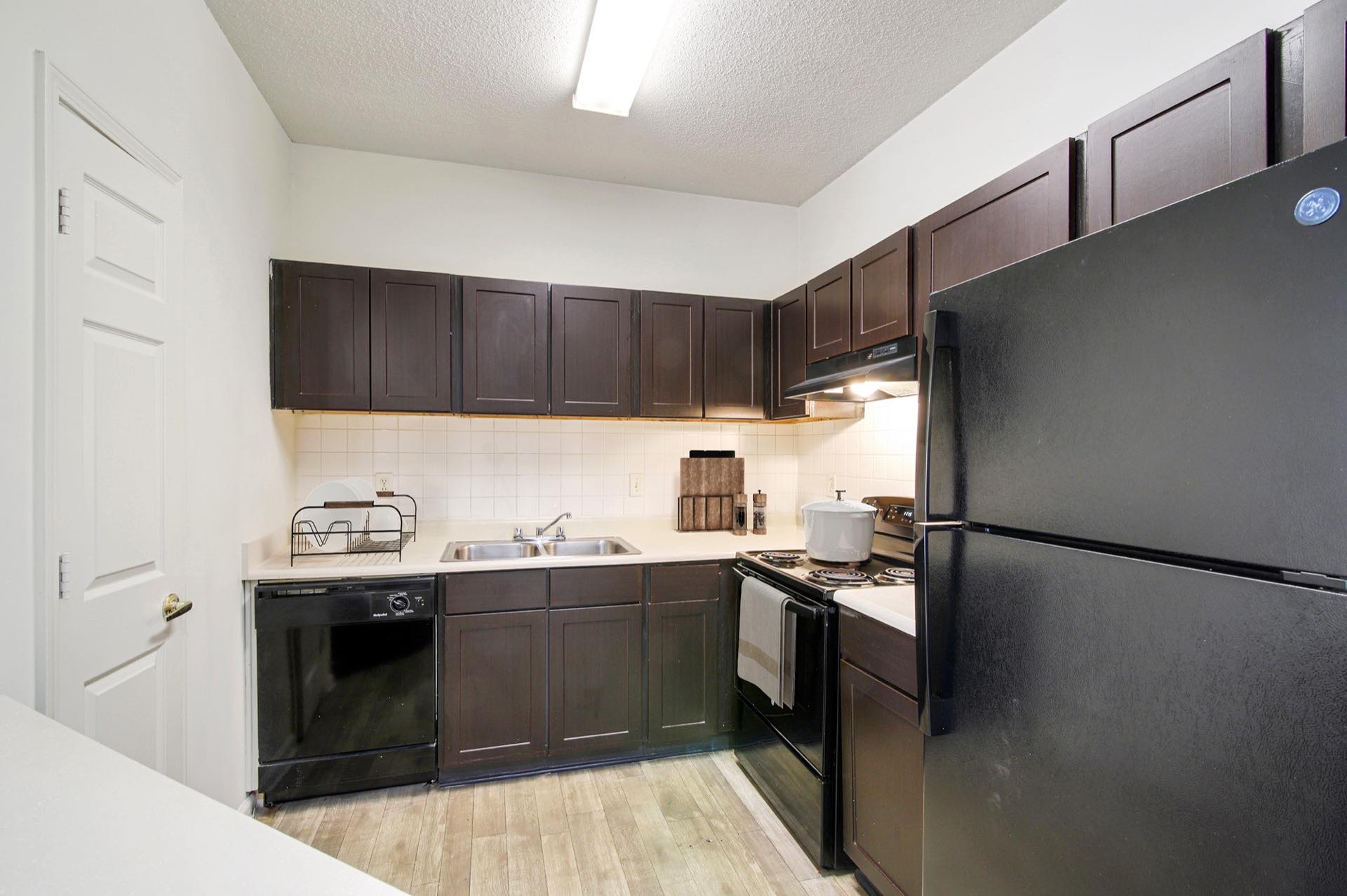 Kitchen with brown cabinets and black appliances